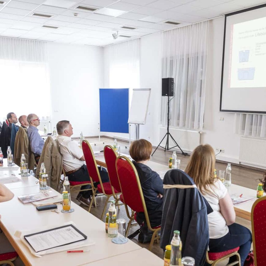 Moderne Konferenz mit Präsentation und aufmerksamem Publikum in Tagungsraum.