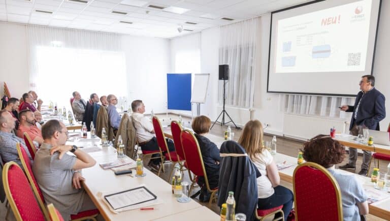 Moderne Konferenz mit Präsentation und aufmerksamem Publikum in Tagungsraum.