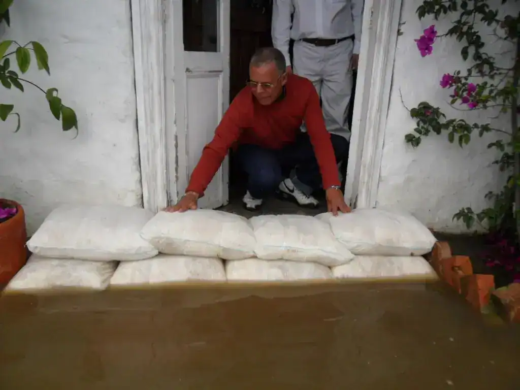 Hochwasserschutz mit Sandsäcken vor einem Gebäude in einer Hochwasser-Katastrophe.