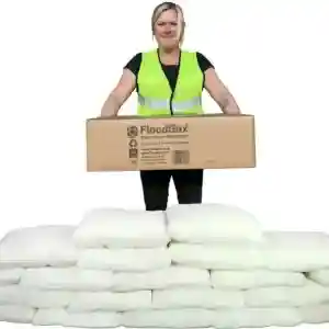 Reinigungskraft mit Sandsäcken und Notfallausrüstung für Hochwasserschutz.